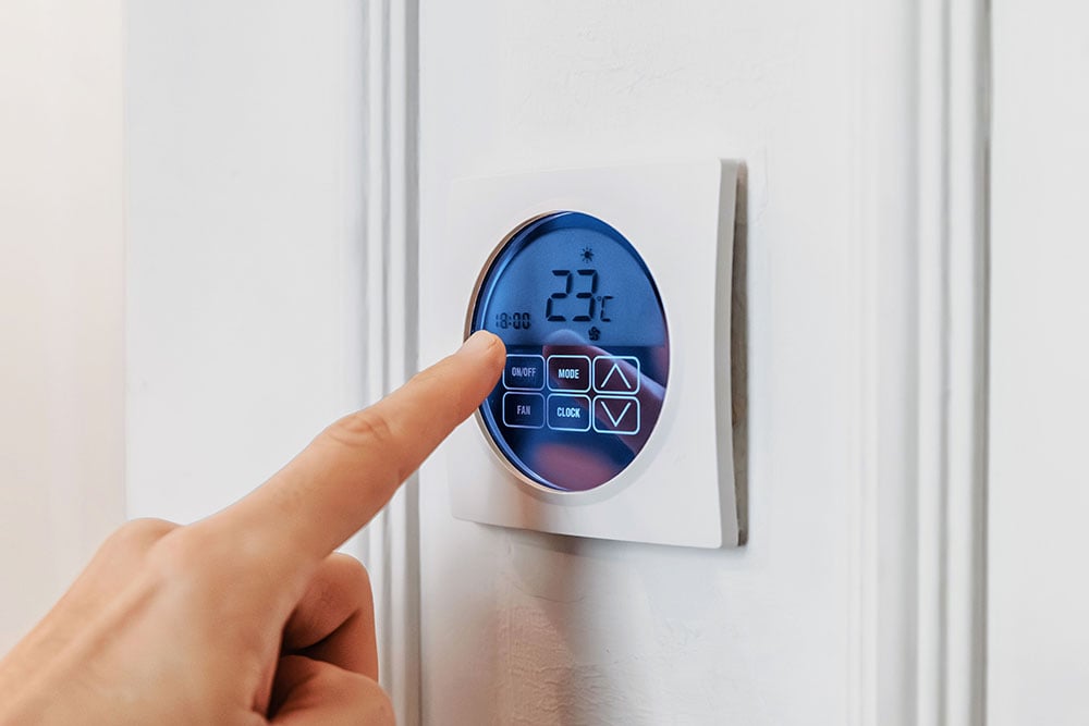 Wandthermostat wird mit Finger bedient